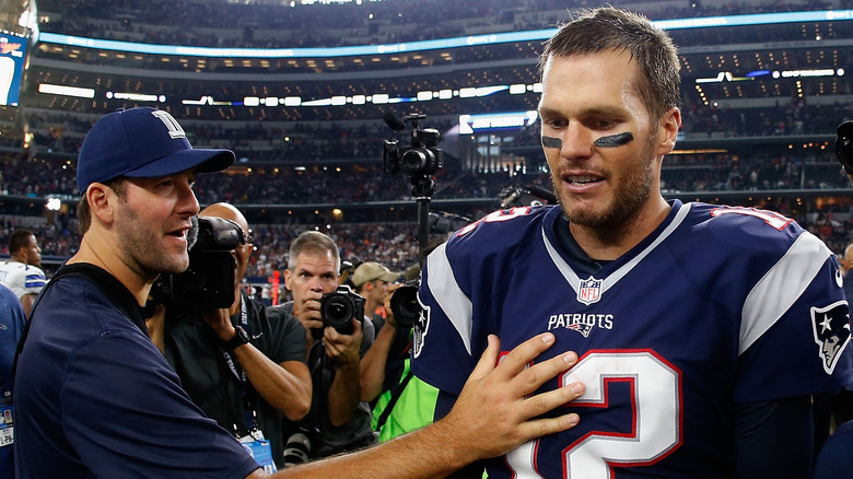 Tony Romo with hand on Tom Brady