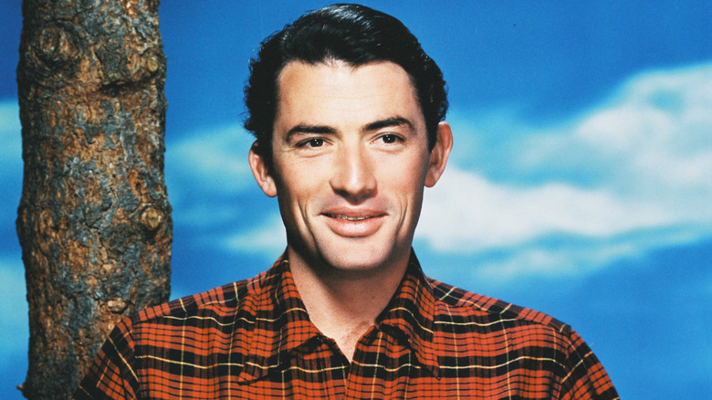Gregory Peck smiling in a plaid shirt