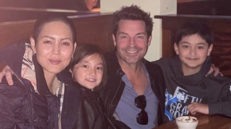 Brennan Elliot sit at a restaurant with Camilla Row and their children.