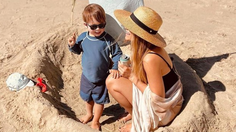 Charlie Wolf Tell and Lauren Conrad laugh together in a sandcastle fort