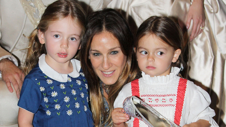 Sarah Jessica Parker crouched down between daughters