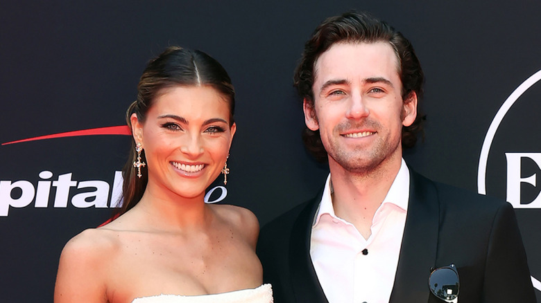 Gianna Tulio, wearing a white dres,s and Ryan Blaney wearing a suit and no tie, smiling beside one another
