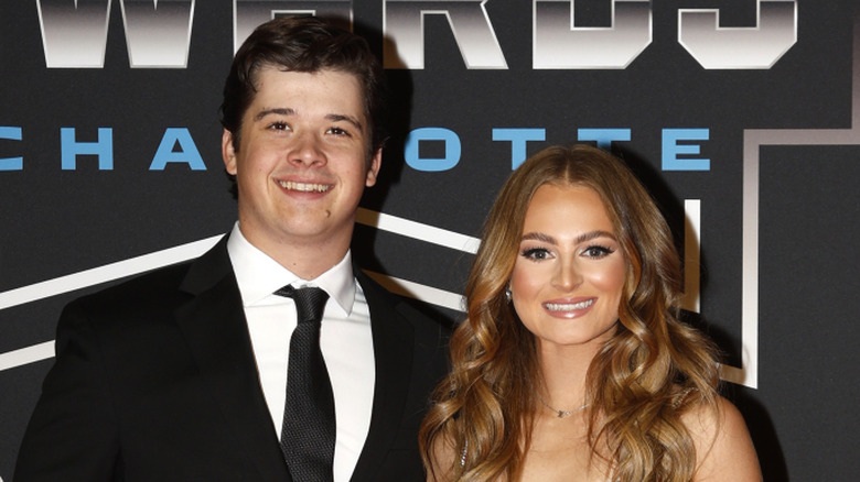 Harrison Burton and Jenna Petty pose together smiling in formal wear before a Nascar awards ceremony