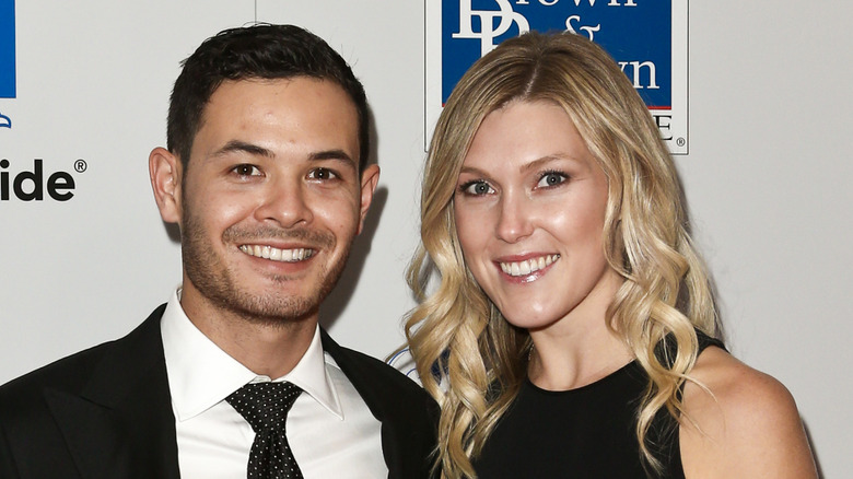 Kyle Larson and Katelyn Sweet smiling together while wearing formal attire and standing by one another's side