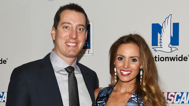 Kyle Busch and Samantha smiling for the press in formal attire
