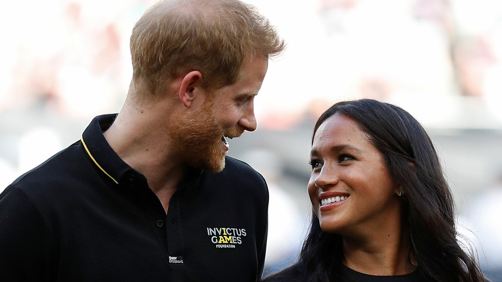 Prince Harry and Meghan Markle smile at each other 