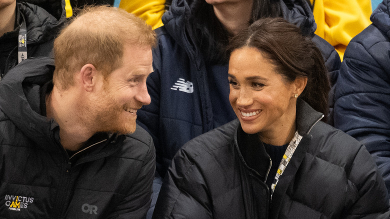 Prince Harry and Meghan Markle smiling at each other