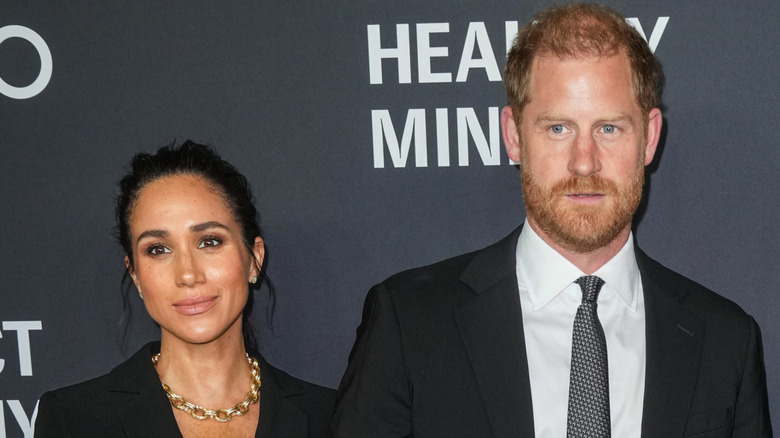 Prince Harry and Meghan Markle pose in 2025