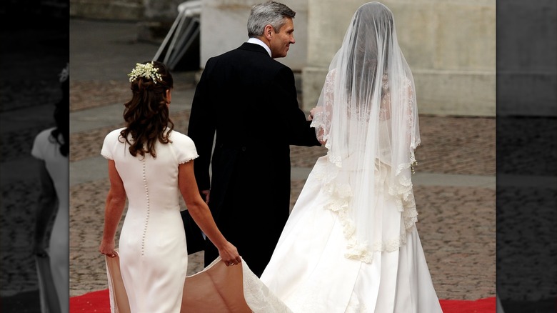 Pippa holding Kate Middleton's dress