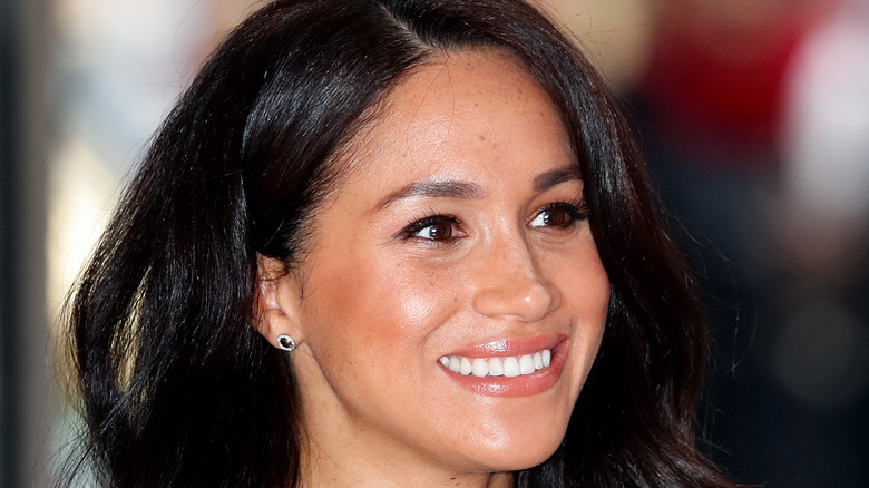 Meghan Markle gives big smile, windswept hair