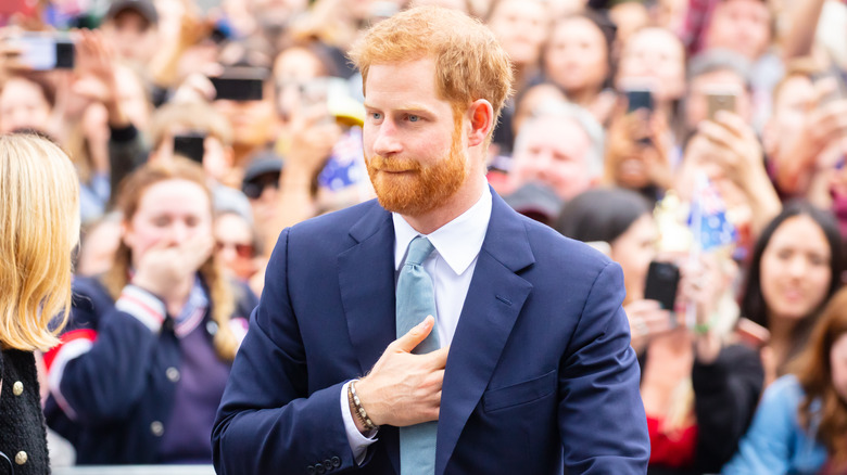 Prince Harry in crowd with hand on chest