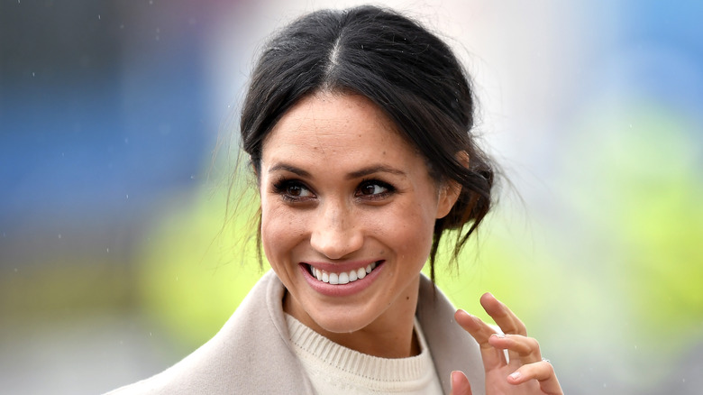 Meghan Markle smiling waving fingers