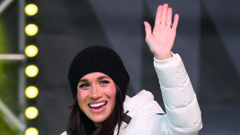 Meghan Markle smiling and waving wearing winter attire