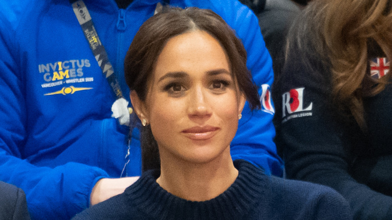 Meghan Markle sitting down while watching a basketball game