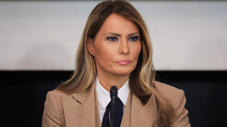Melania Trump sits at a roundtable discussion in a biege suit