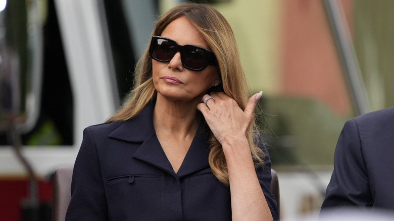 Melania Trump adjusting her hair.