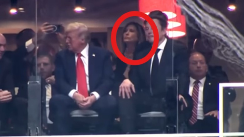Mystery woman looking on while sitting in State Farm Stadium suite behind President Donald J. Trump and Elon Musk