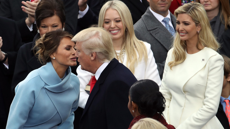 Melania Trump kissing Donald Trump with Tiffany and Ivanka looking on
