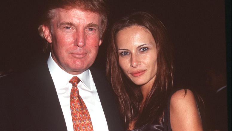 Melania Trump posing with dark hair no bangs next to Donald Trump