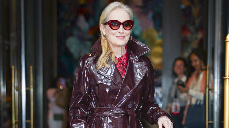 Meryl Streep outdoors in a brown leather coat.