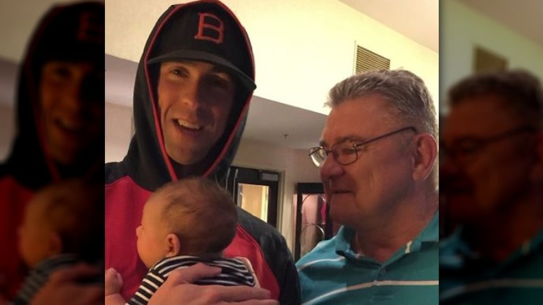 Michael Phelps posing with father and baby