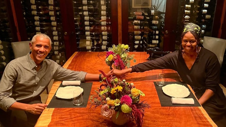 Barack Obama and Michelle Obama holdings hands at a restaurant