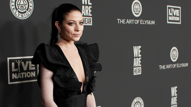 Michelle Trachtenberg poses in formal black dress while donning a ponytail