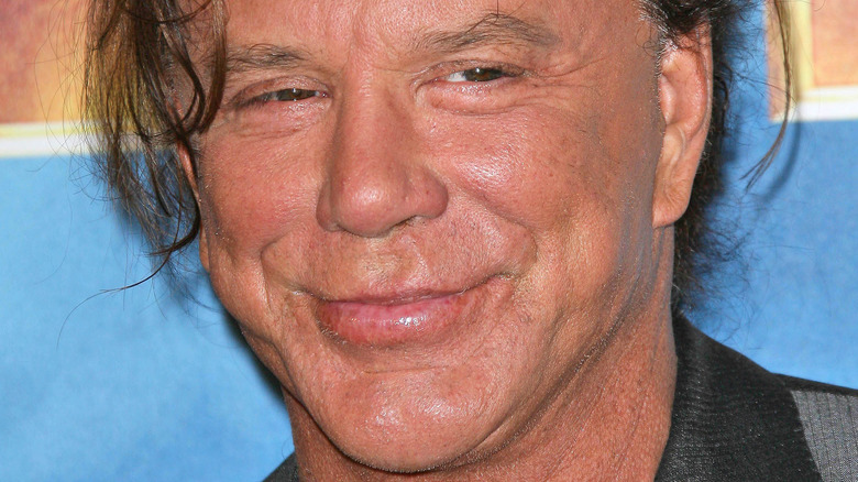 Mickey Rourke smiles with hair pulled back