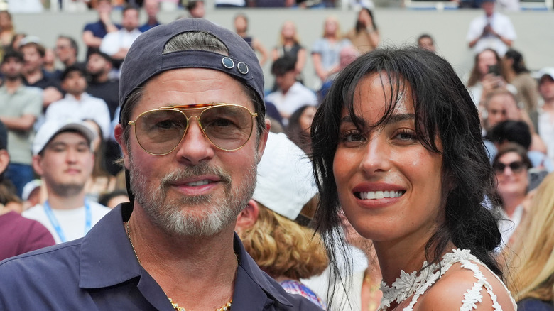 Brad Pitt and Ines de Ramon smiling outdoors in a crowd