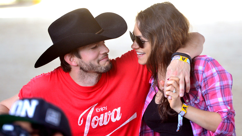 Ashton Kutcher with his arm around Mila Kunis