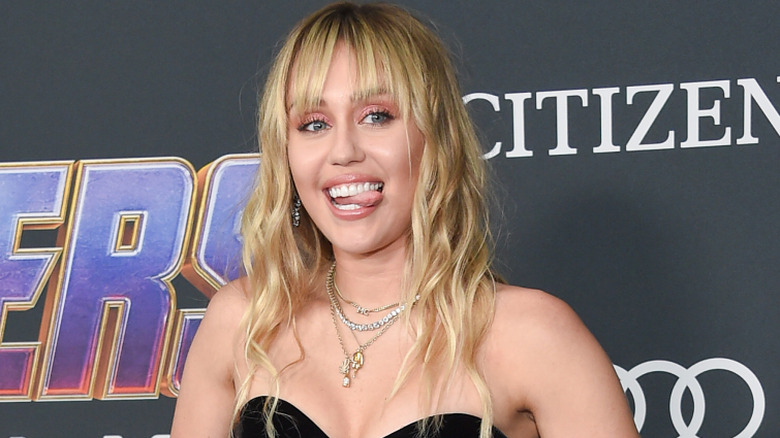 Miley Cyrus smiling in a black dress at the premiere of 'Avengers Endgame.'