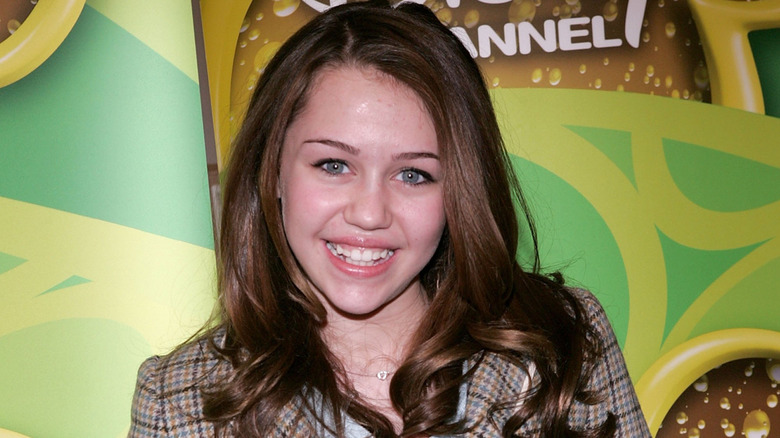 A young Miley Cyrus smiling