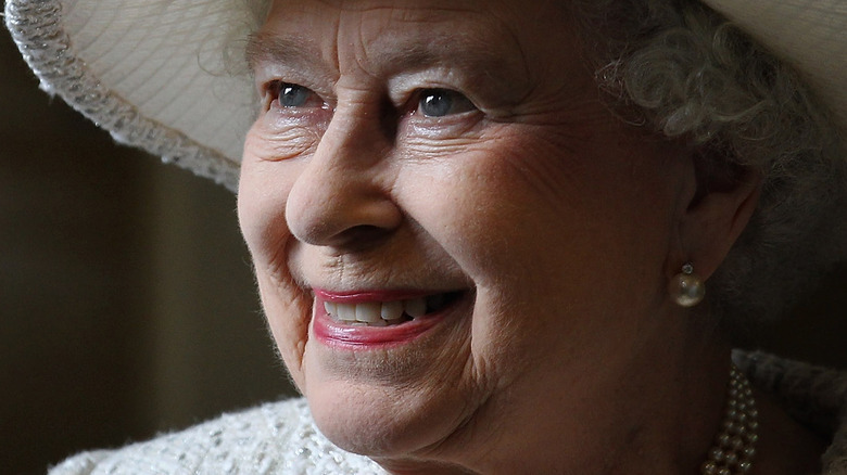 Queen Elizabeth II wearing cream hat and smiling