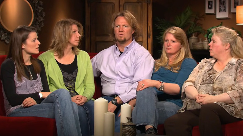 Brown family seated on couch