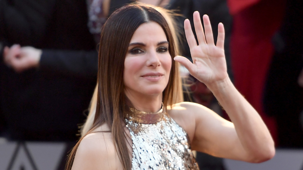 Sandra Bullock walking and waving on red carpet