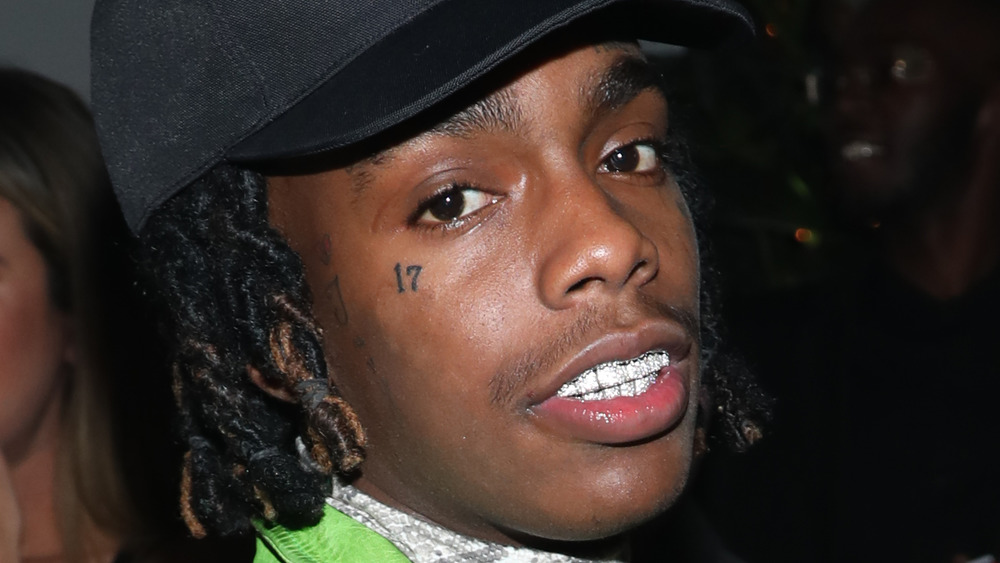 YNW Melly sporting a grill and ballcap 