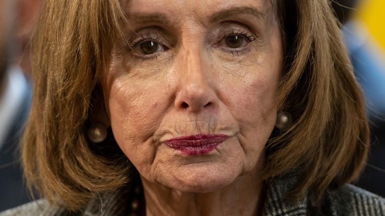Nancy Pelosi, looking serious and wearing maroon lipstick