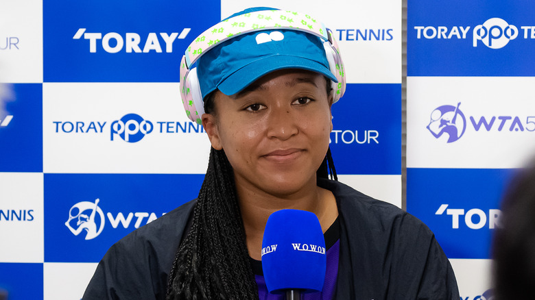 Naomi Osaka holding microphone