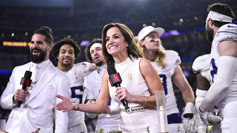 Dianna Russini on the field talking to football players.