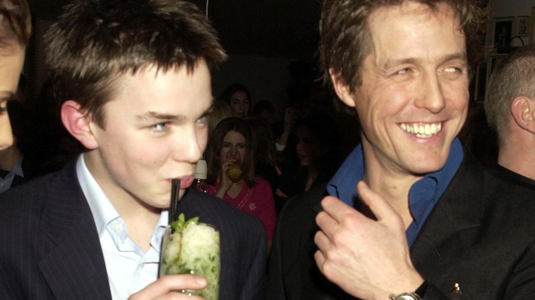 Nicholas Hoult smiling next to Hugh Grant