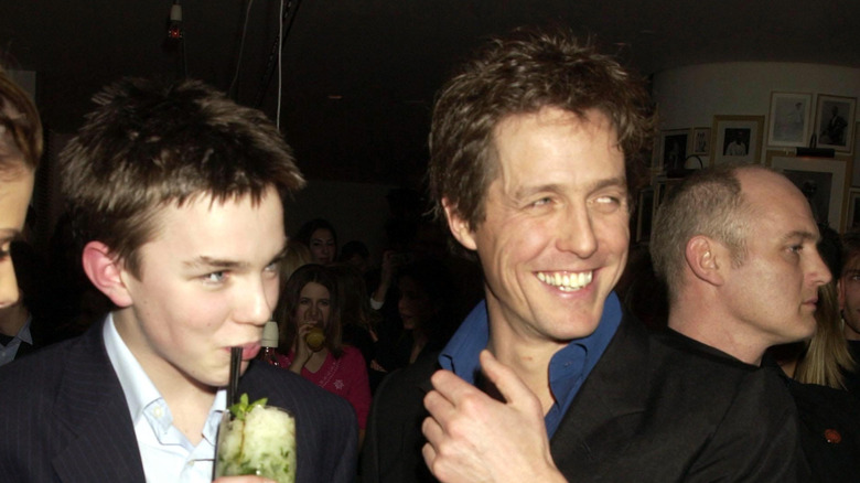 Nicholas Hoult smiling next to Hugh Grant