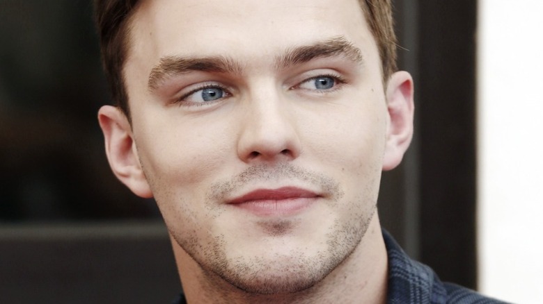 Nicholas Hoult smiling, looking to side