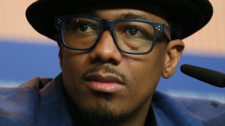 Nick Cannon wearing hat and glasses