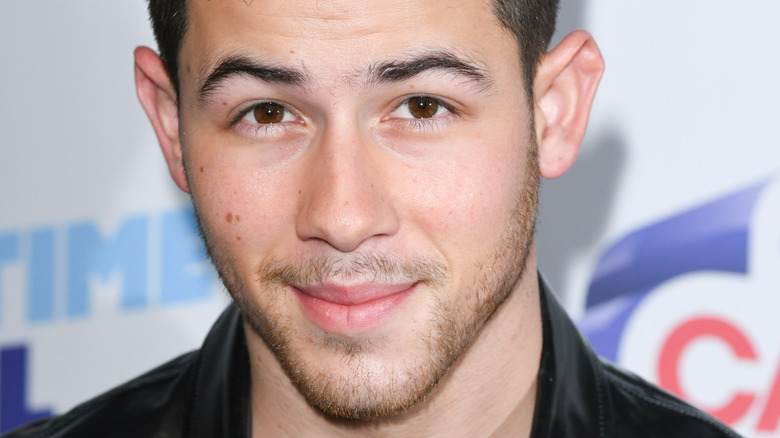 Nick Jonas wears a striped leather jacket