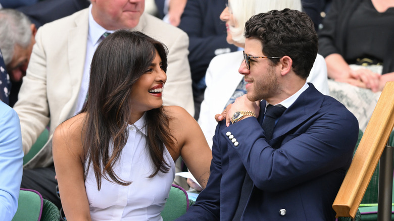 Priyanka Chopra and Nick Jonas laugh together during tennis event in 2025