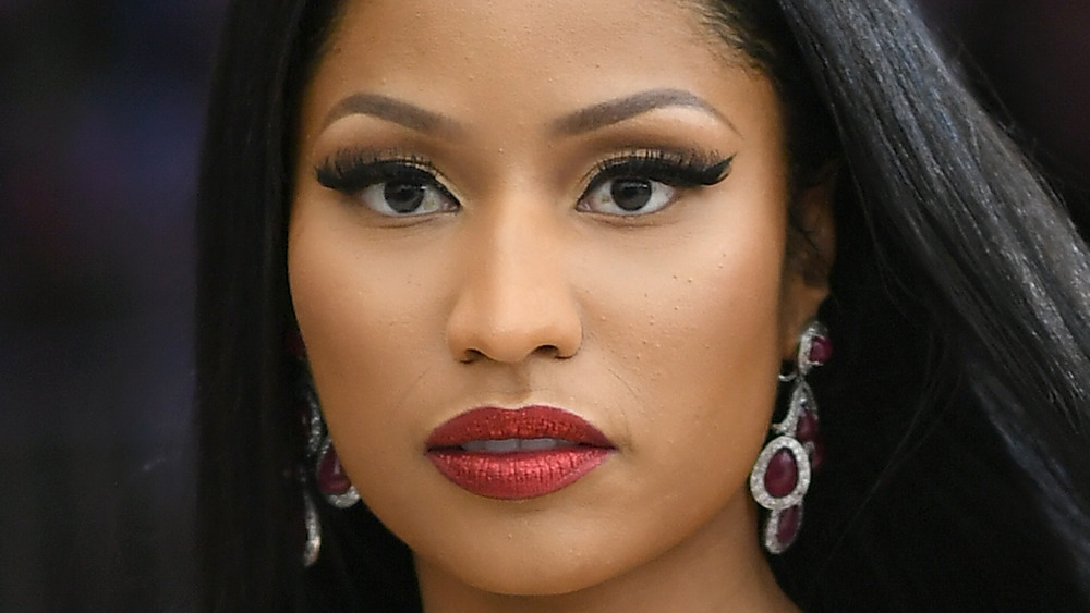 Nicki Minaj looks intensely at something while posing for a photo