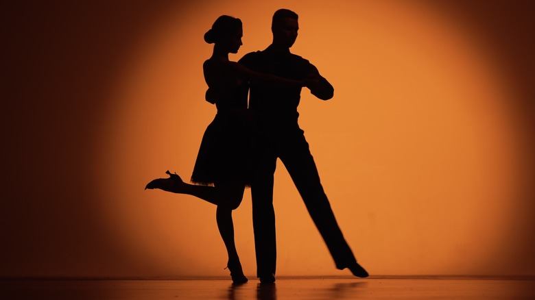 Couple silhouette dancing under spotlight
