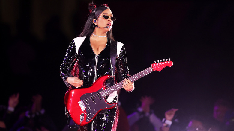 H.E.R. on stage with guitar