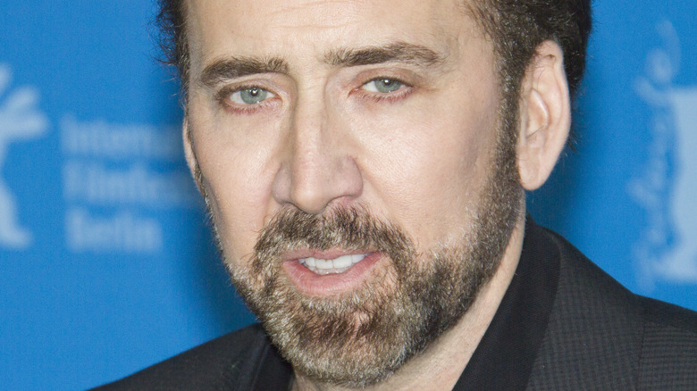 Nicolas Cage poses in a dark suit