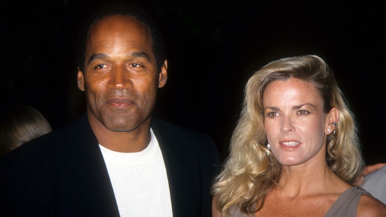 O.J. Simpson smiling, Nicole Brown Simpson grimacing